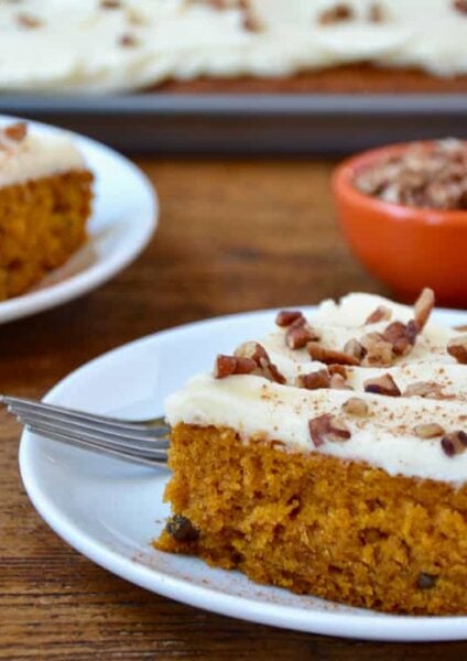 A slice of the best Pumpkin Bars with Cream Cheese Frosting on a white plate