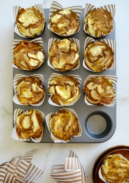 A muffin tin containing Cream Cheese Pumpkin Muffins