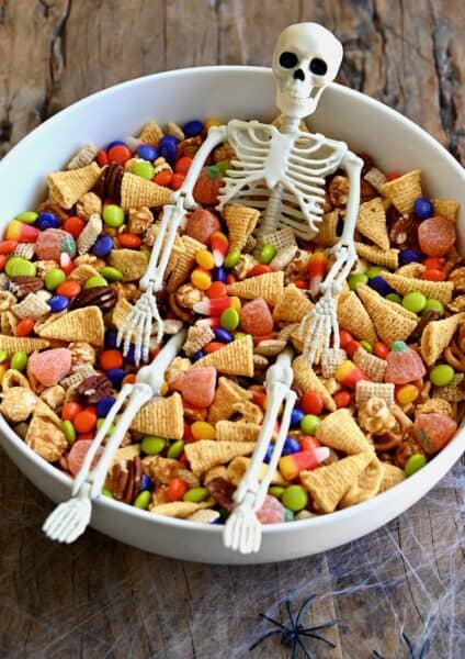 Easy Halloween snack mix with Chex cereal, pecans, candy corn, mini pretzels and M&Ms in a large serving bowl.