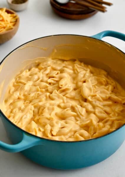 Creamy stovetop mac and cheese in a light blue stockpot.